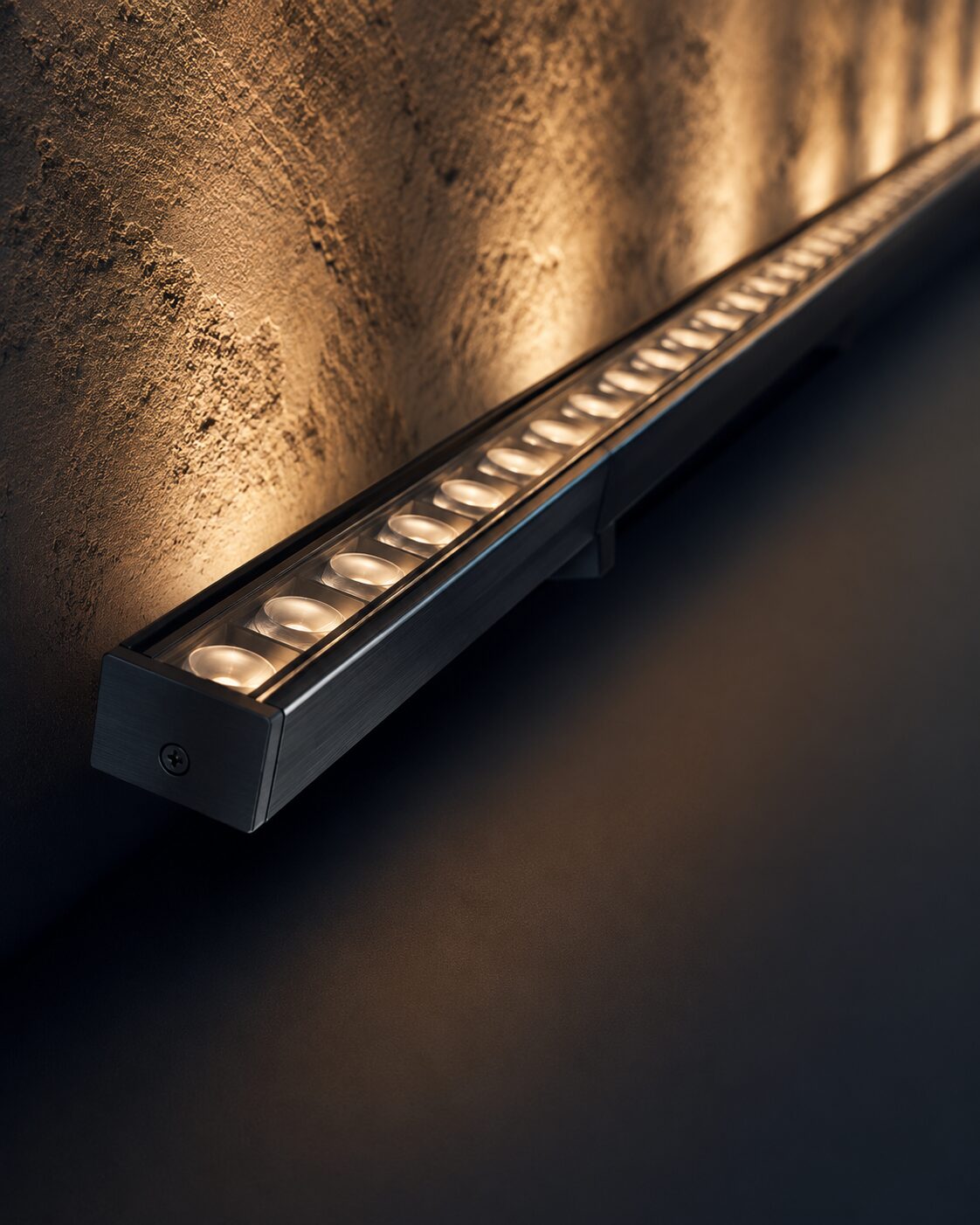 Lineer wallwasher LED armatür — anodize alüminyum gövde ve lens detayı, yakın çekim